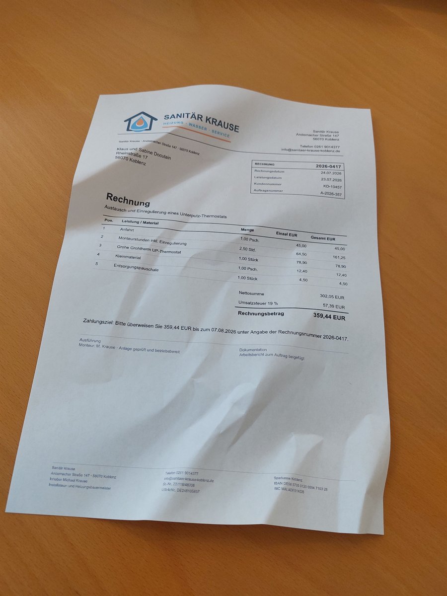 Creased demo invoice photographed at an oblique angle on a desk