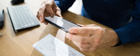 Truck driver in front of his truck holding freight documents